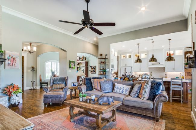 Living room featuring arched walkways, dark wood-style flooring, ornamental molding, and a ceiling fan | Image 9
