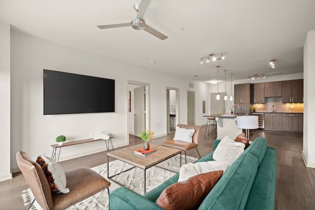 Living room with wine cooler, ceiling fan, dark wood finished floors, and track lighting | Image 22