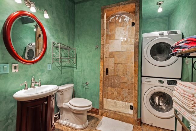Full bath with toilet, a stall shower, stacked washer / drying machine, and vanity | Image 46