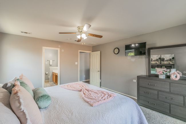 Carpeted bedroom featuring ceiling fan and ensuite bathroom | Image 21