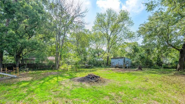 Expansive backyard with lush greenery and mature trees, offering ample space for outdoor activities and relaxation. | Image 8