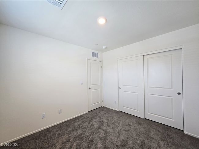 Unfurnished bedroom featuring dark colored carpet, baseboards, and a closet | Image 24