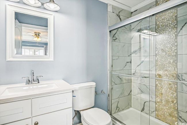Full bath with a marble finish shower, vanity, and ornamental molding | Image 24
