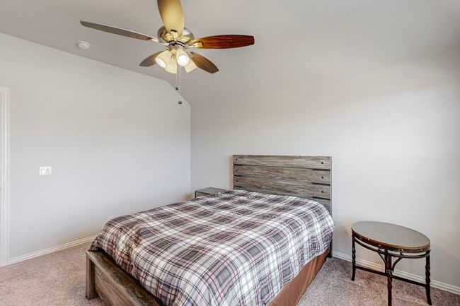 Bedroom featuring a ceiling fan, carpet, lofted ceiling, and baseboards | Image 22