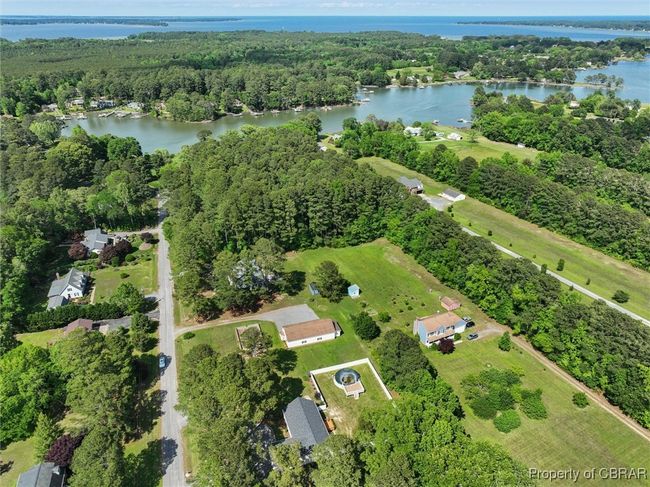 Aerial overview of property's location with a nearby body of water and a heavily wooded area | Image 38