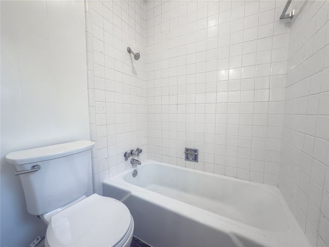 Bathroom with tiled shower / bath combo and toilet | Image 13