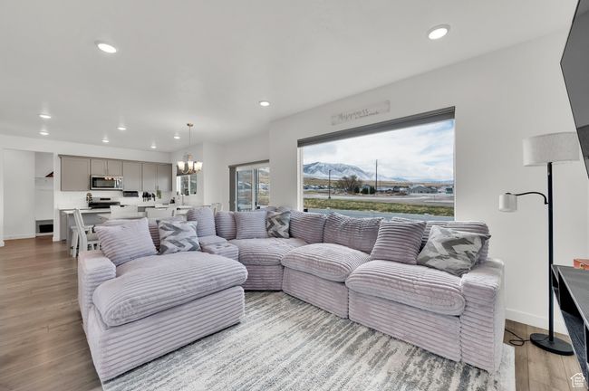 Living area featuring a notable chandelier, baseboards, light wood-style floors, and recessed lighting | Image 10