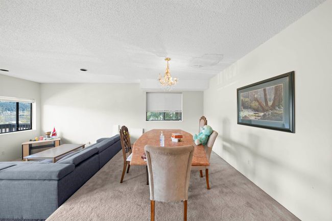 Carpeted dining room with a chandelier and a textured ceiling | Image 26