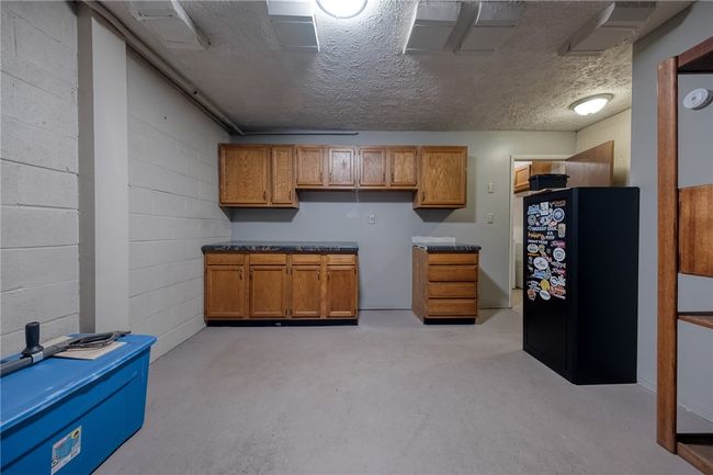 immaculate garage space with work bench and storage | Image 21
