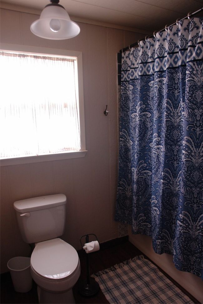 Bathroom with curtained shower and toilet | Image 17