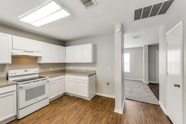 Kitchen featuring white cabinetry, dark hardwood / wood-style flooring, and white electric range oven | Image 12