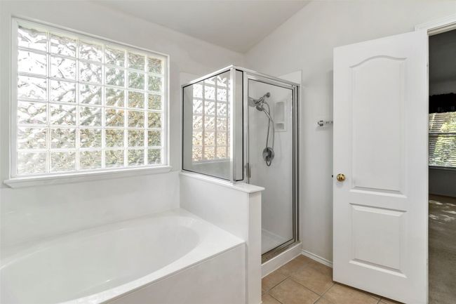 Bathroom featuring a shower stall, a bath, and tile patterned flooring | Image 24