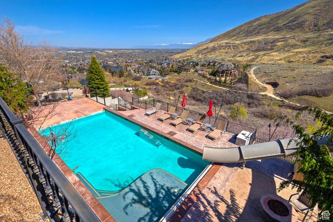 Pool with a patio, a mountain view, and fence | Image 60