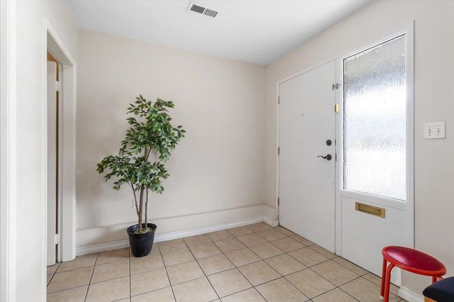 Entrance foyer featuring light tile patterned flooring and visible vents | Image 6