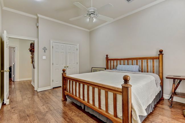 Bedroom featuring hardwood / wood-style floors, crown molding, baseboards, and a ceiling fan | Image 21