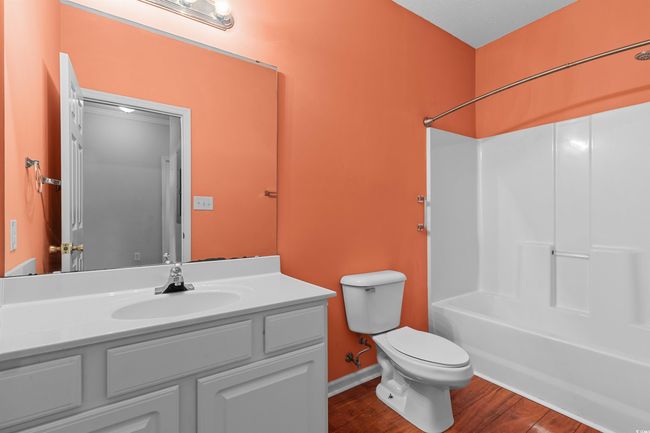 Full bathroom with toilet, vanity, shower combination, wood finished floors, and baseboards | Image 8