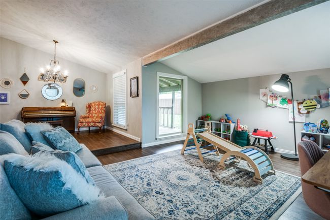 Living area featuring a chandelier, wood finished floors, and lofted ceiling | Image 13