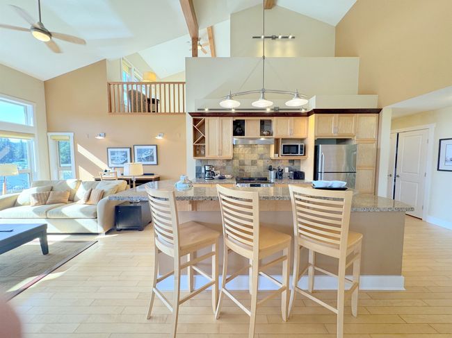 Kitchen with stainless steel appliances, high vaulted ceiling, backsplash, light brown cabinets, and ceiling fan | Image 16