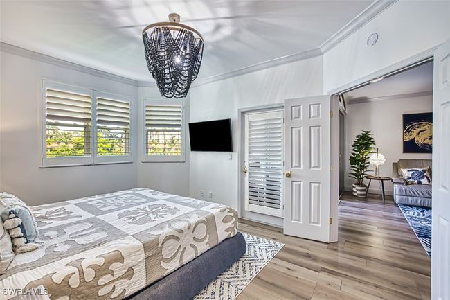 Bedroom featuring crown molding, wood finished floors, and a chandelier | Image 33