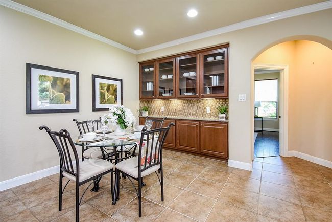 Set beside the kitchen, this breakfast corner is well-lit and enhanced by custom upper glass cabinets with built-in lighting, creating a café-like atmosphere. | Image 17