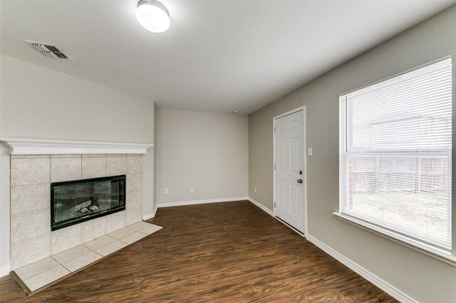Unfurnished living room featuring dark hardwood / wood-style floors and a fireplace | Image 8