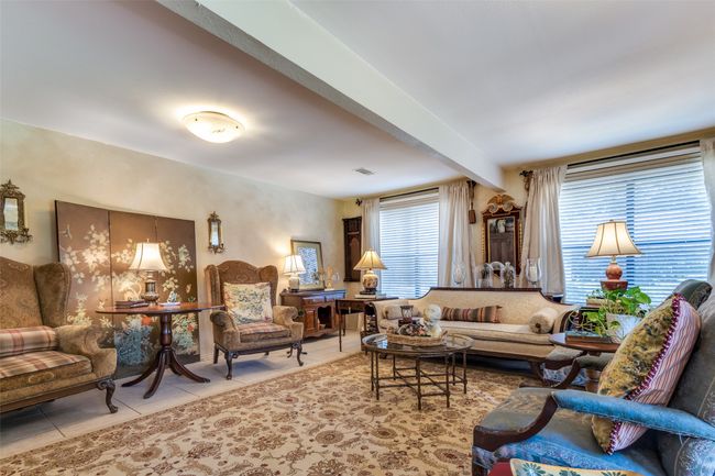 Living room with tile patterned flooring and beam ceiling | Image 10