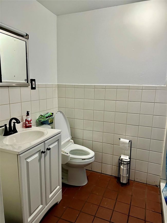 Bathroom with tile patterned floors, vanity, tile walls, and toilet | Image 24