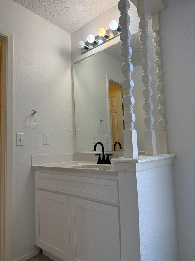 Bathroom featuring a textured ceiling and vanity | Image 13