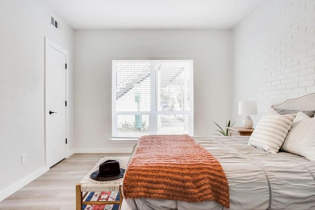 Bedroom featuring brick wall and hardwood / wood-style floors | Image 5