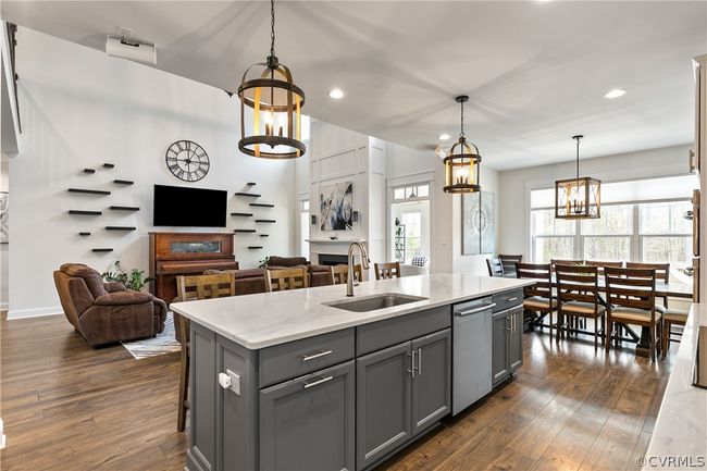 Kitchen with a kitchen island with sink, gray cabinets, dark hardwood / wood-style floors, and hanging light fixtures | Image 16