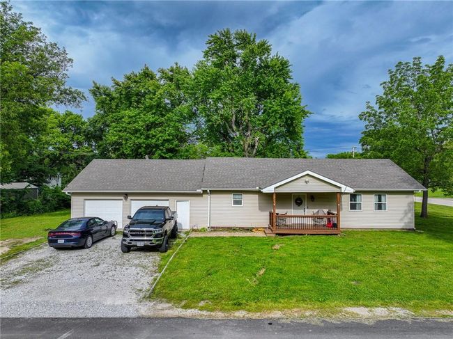 Single story home featuring an attached garage, a front lawn, driveway, and roof with shingles | Image 4