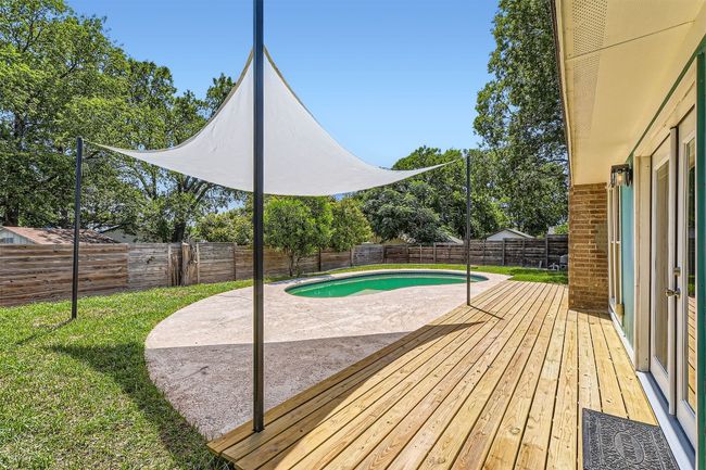 View of swimming pool featuring a patio area, a fenced backyard, and a wooden deck | Image 20
