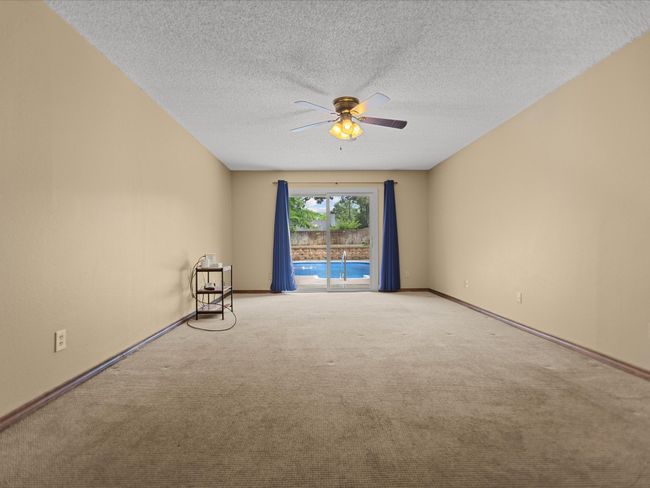 Master Bedroom Carpeted empty room featuring a ceiling fan, baseboards, and a textured ceiling | Image 22