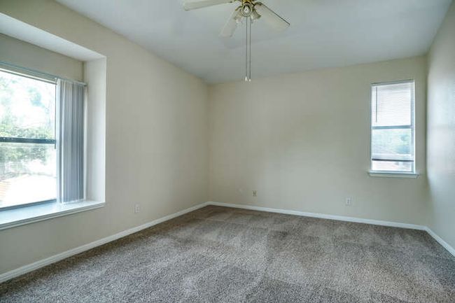 Carpeted empty room featuring healthy amount of natural light, a ceiling fan, and baseboards | Image 4