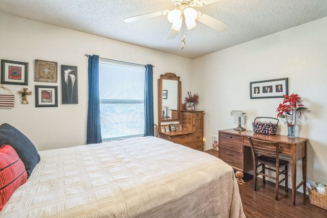 Bedroom featuring a ceiling fan, wood finished floors, and a textured ceiling | Image 20