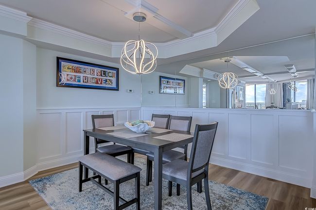 Dining room with light wood-type flooring, a chandelier, and crown molding | Image 12