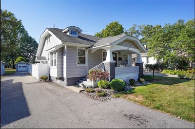 View of front of property with a garage, a front lawn, covered porch, and an outbuilding | Image 2