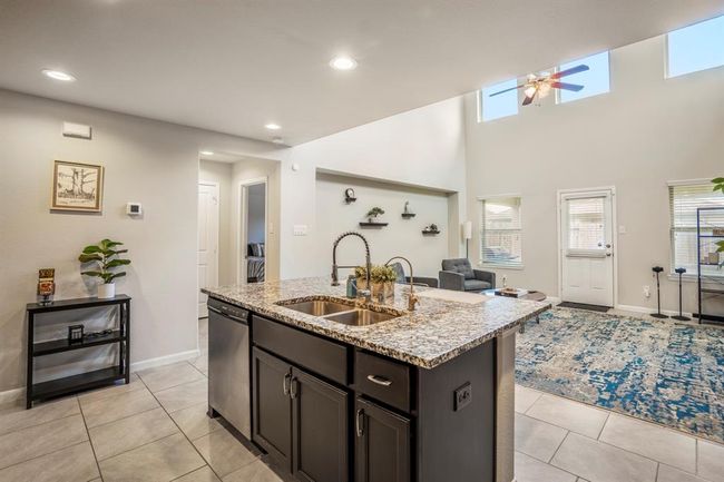 Dual sinks in the island with a dishwasher and space to store your cleaning supplies. | Image 13
