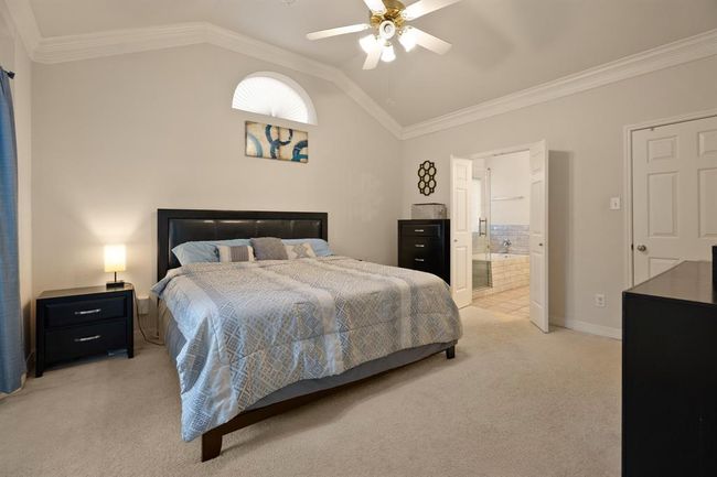 Your primary bedroom is located on the first floor, and features crown molding and soaring ceilings. | Image 10