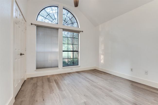 Unfurnished room featuring wood finished floors, ceiling fan, and high vaulted ceiling | Image 14