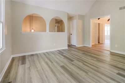 Spare room featuring vaulted ceiling and light hardwood / wood-style floors | Image 2