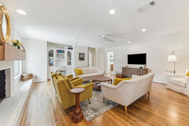 Bright and spacious family room with elegant built-in shelving, recessed lighting, and a ceiling fan. | Image 8