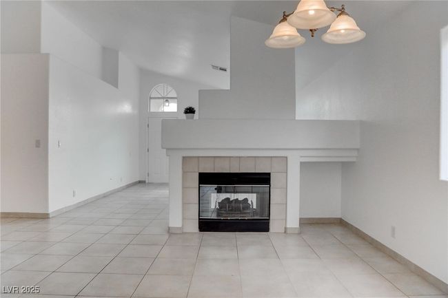 Living room featuring a vaulted ceiling & fireplace | Image 5