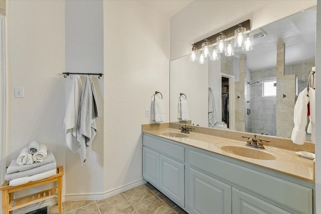 Bathroom featuring double vanity, a shower stall, and baseboards | Image 20