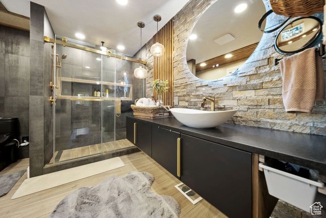 Full bathroom with vanity, a stall shower, toilet, and wood finished floors | Image 16