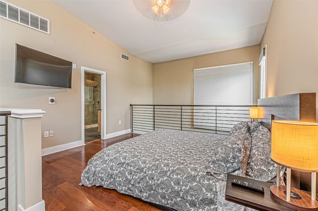 Bedroom featuring hardwood / wood-style floors, vaulted ceiling, and connected bathroom | Image 17