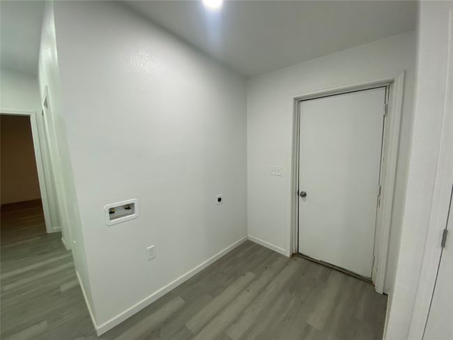Clothes washing area featuring light wood finished floors, hookup for a washing machine, hookup for an electric dryer, and baseboards | Image 17