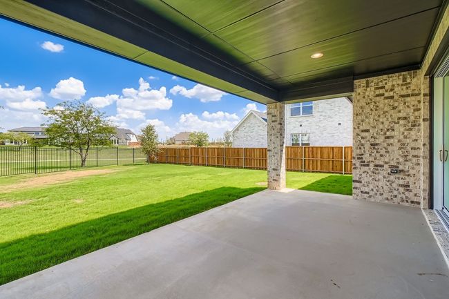 Fenced backyard with a patio | Image 26