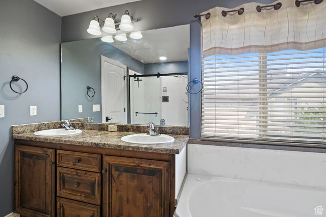 Bathroom featuring a shower stall, a garden tub, double vanity, and a sink | Image 14