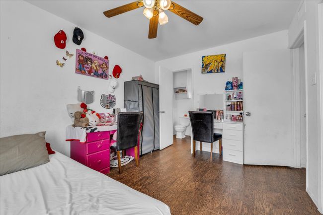 Bedroom featuring wood finished floors, a desk, and a ceiling fan | Image 10